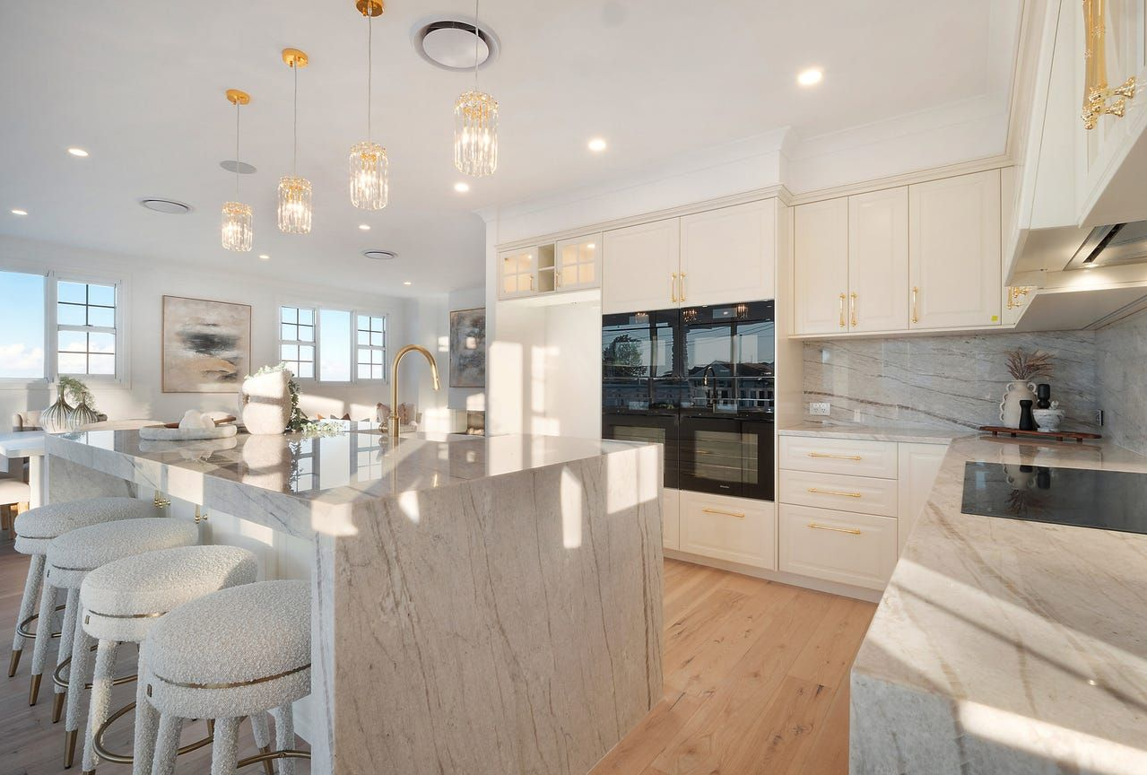A light coloured kitchen with white fluffy chairs under benchtop — Universal Marble & Granite In Woolgoolga, NSW