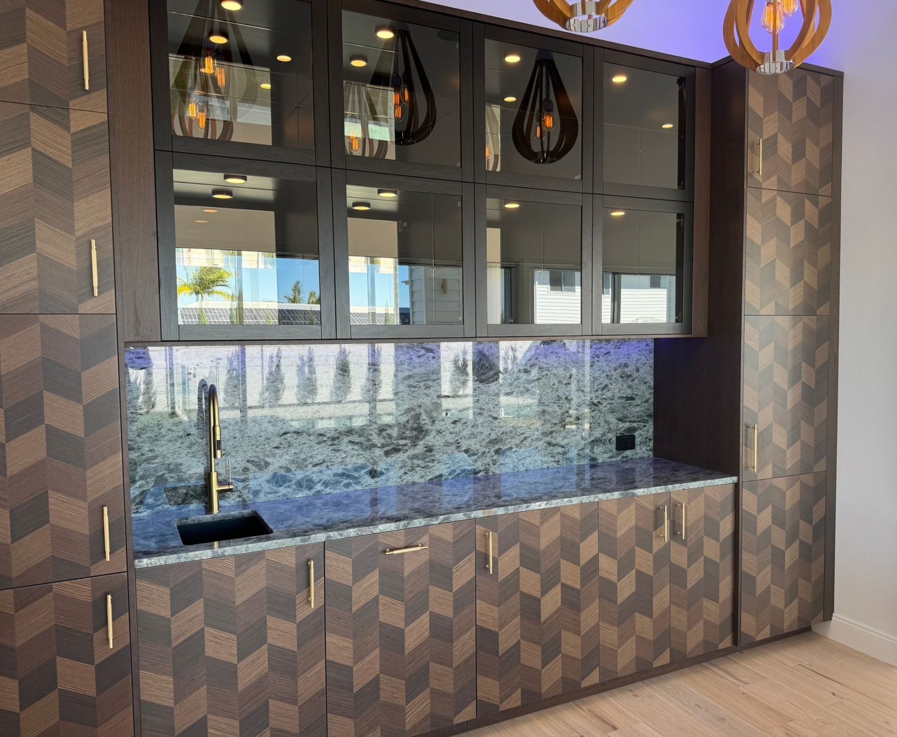 A Kitchen With black glass Cabinets And A Large Island — Universal Marble & Granite In Woolgoolga, NSW