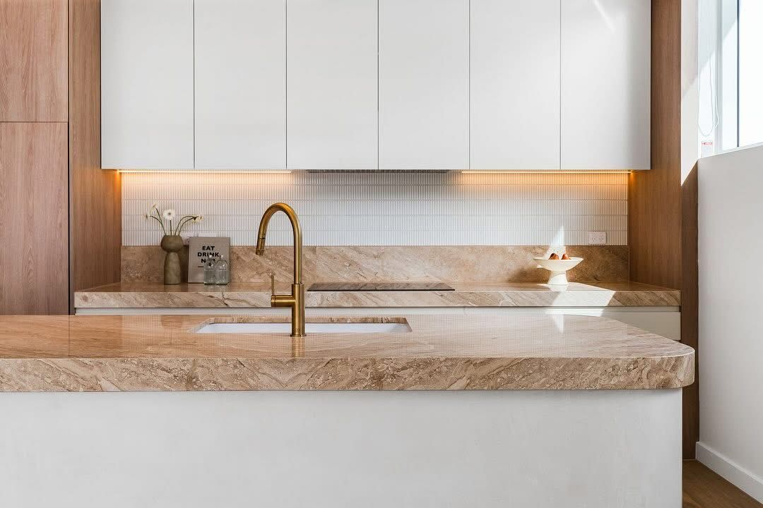 A large kitchen space with stone kitchen top and white cabinets — Universal Marble & Granite In Woolgoolga, NSW
