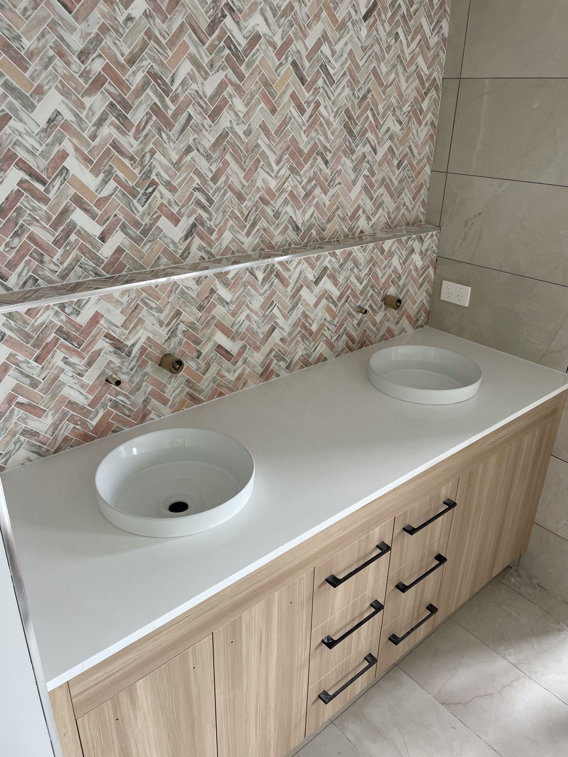 A bathroom shelf with sink up against a tiled wall — Universal Marble & Granite In Woolgoolga, NSW