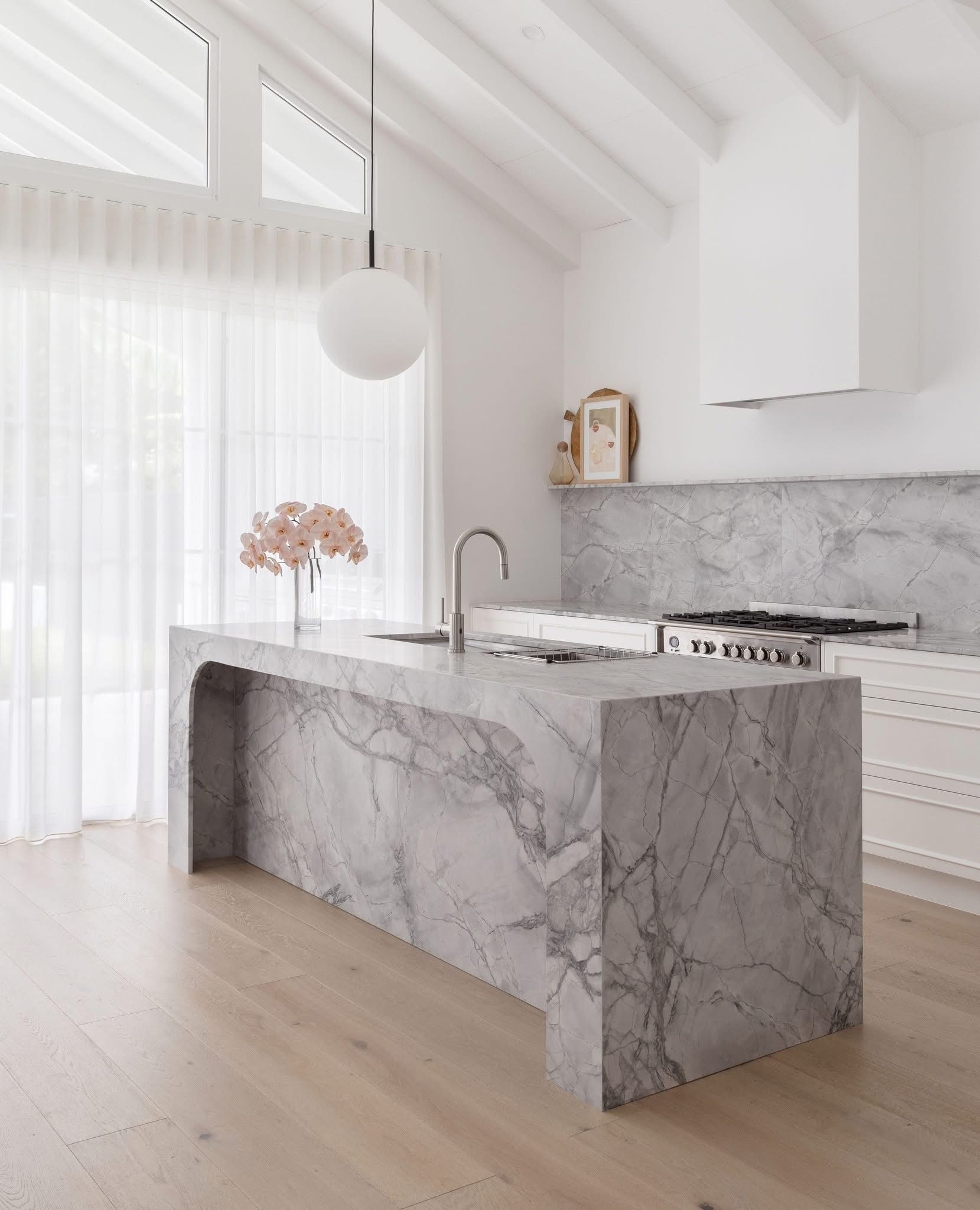 A Large grey stone kitchen space with one hanging light — Universal Marble & Granite In Woolgoolga, NSW