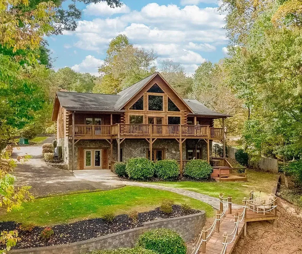 An aerial view of a large log cabin surrounded by trees.