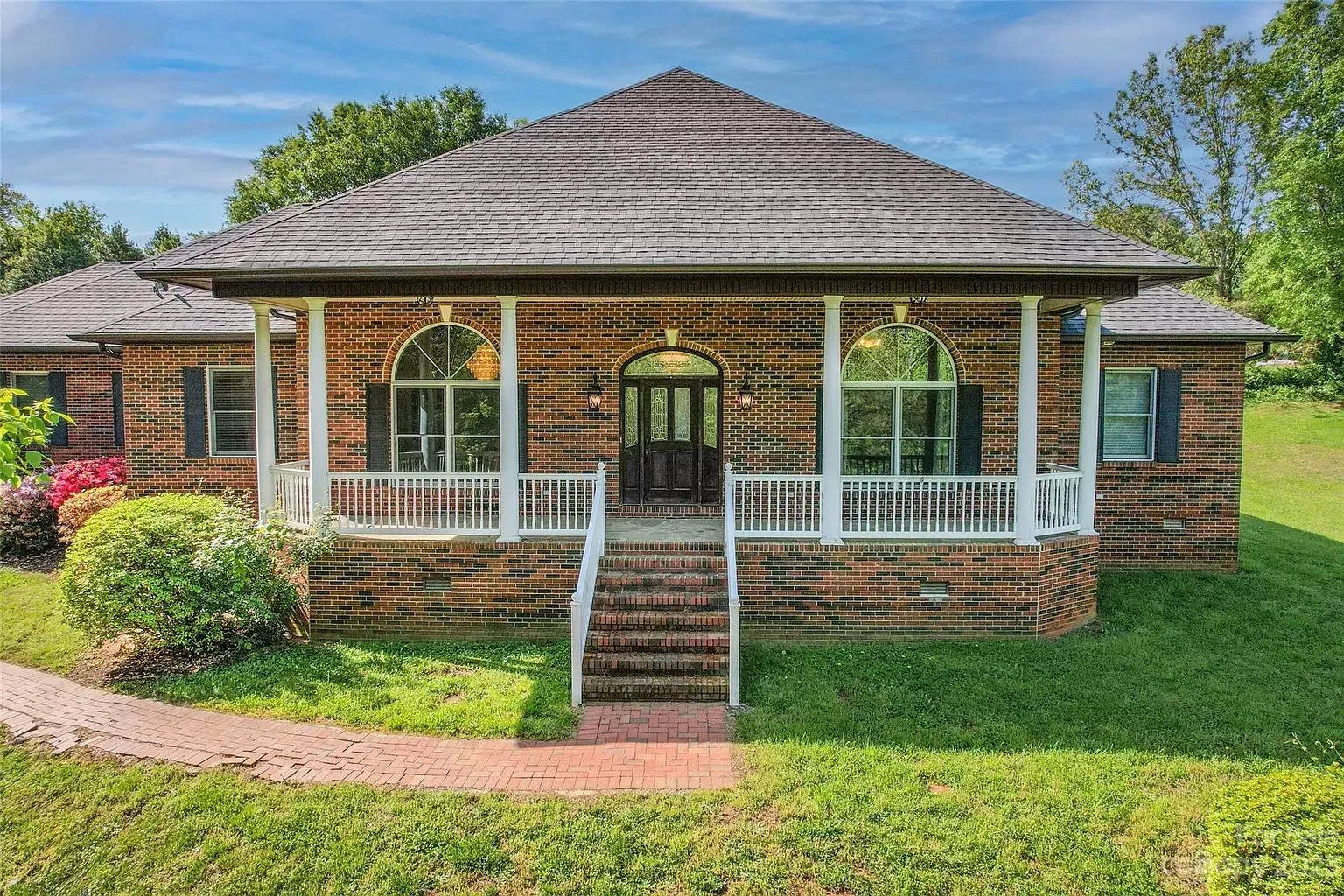 A brick house with a thatched roof and a porch
