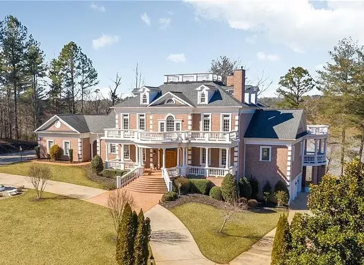 An aerial view of a large brick house surrounded by trees.