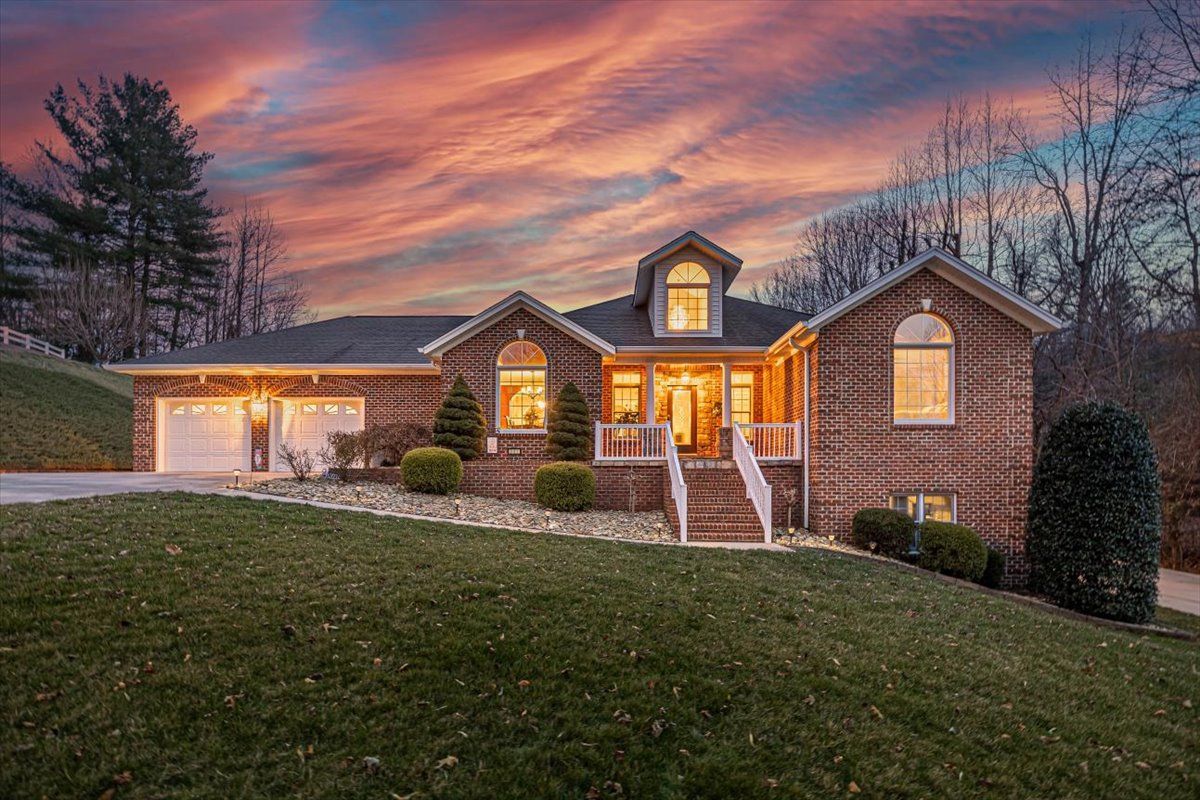 A large brick house with a sunset in the background