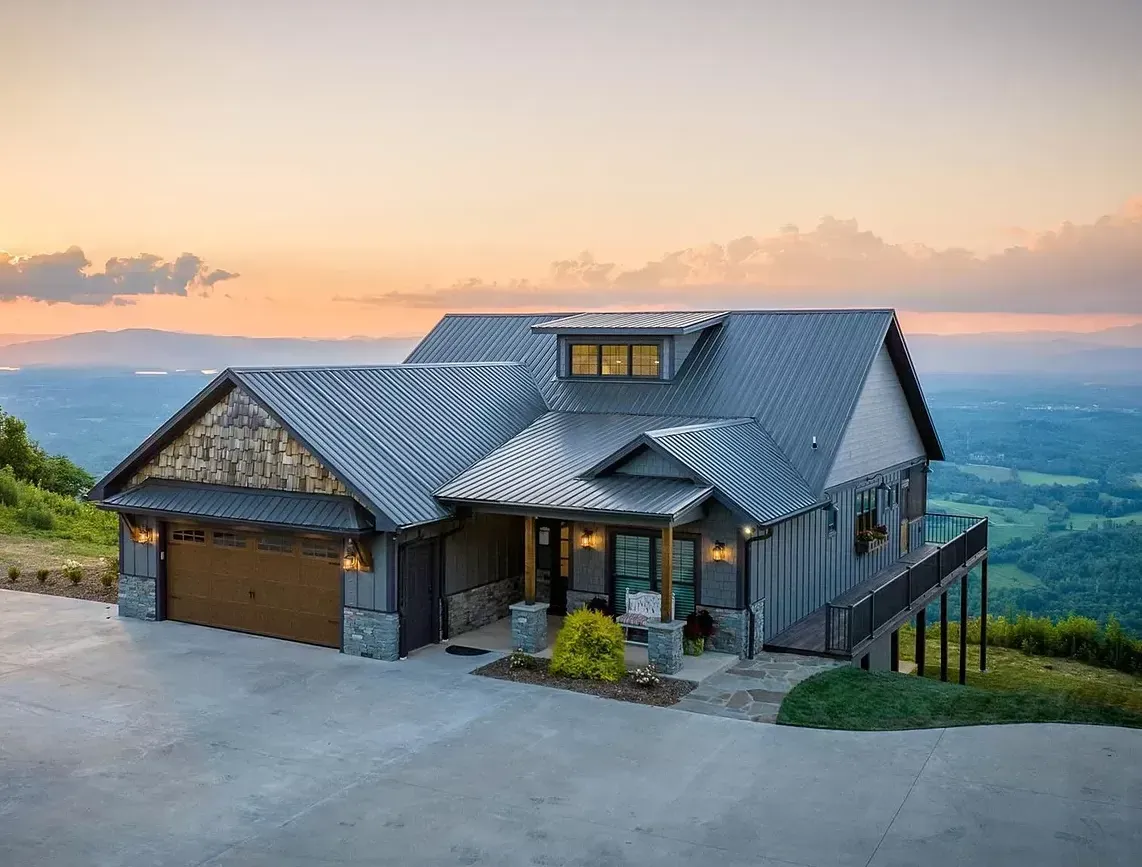 A large house is sitting on top of a hill overlooking a valley.
