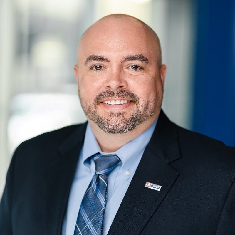 A man in a blue suit and white shirt is smiling for the camera.