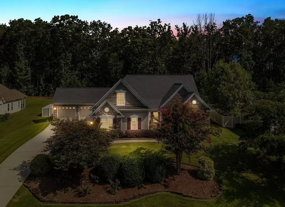 An aerial view of a house with trees in the background at night.