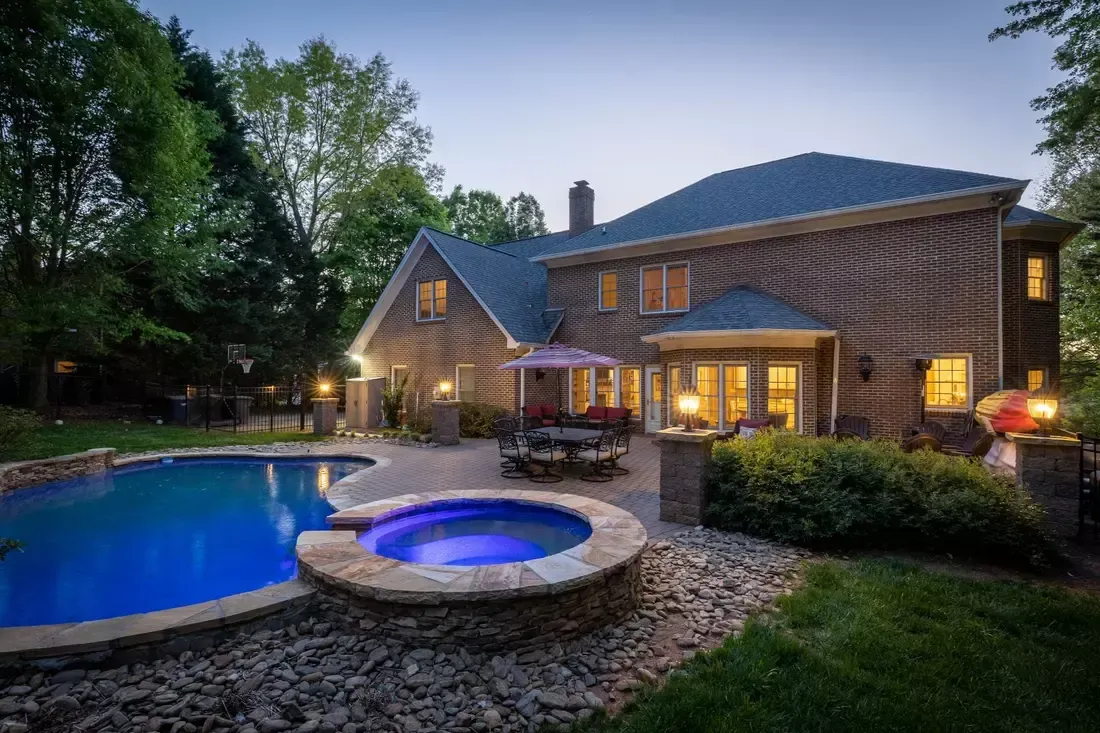 A large brick house with a large swimming pool