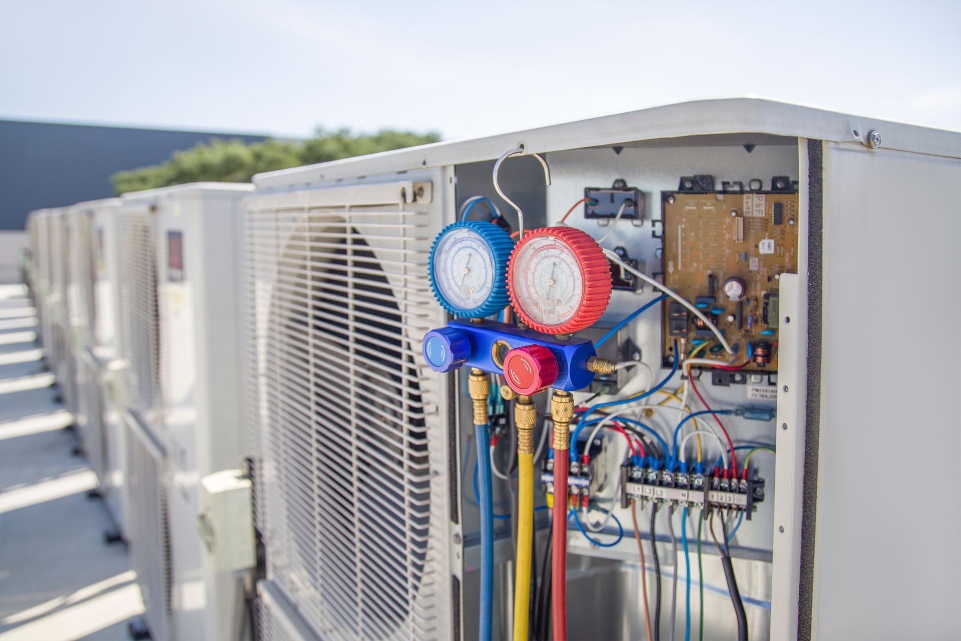 an outdoor air conditioning unit with its panel open, showing internal electrical components.