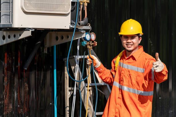 A technician is smiling while fixing a heater, delivering essential heating services.