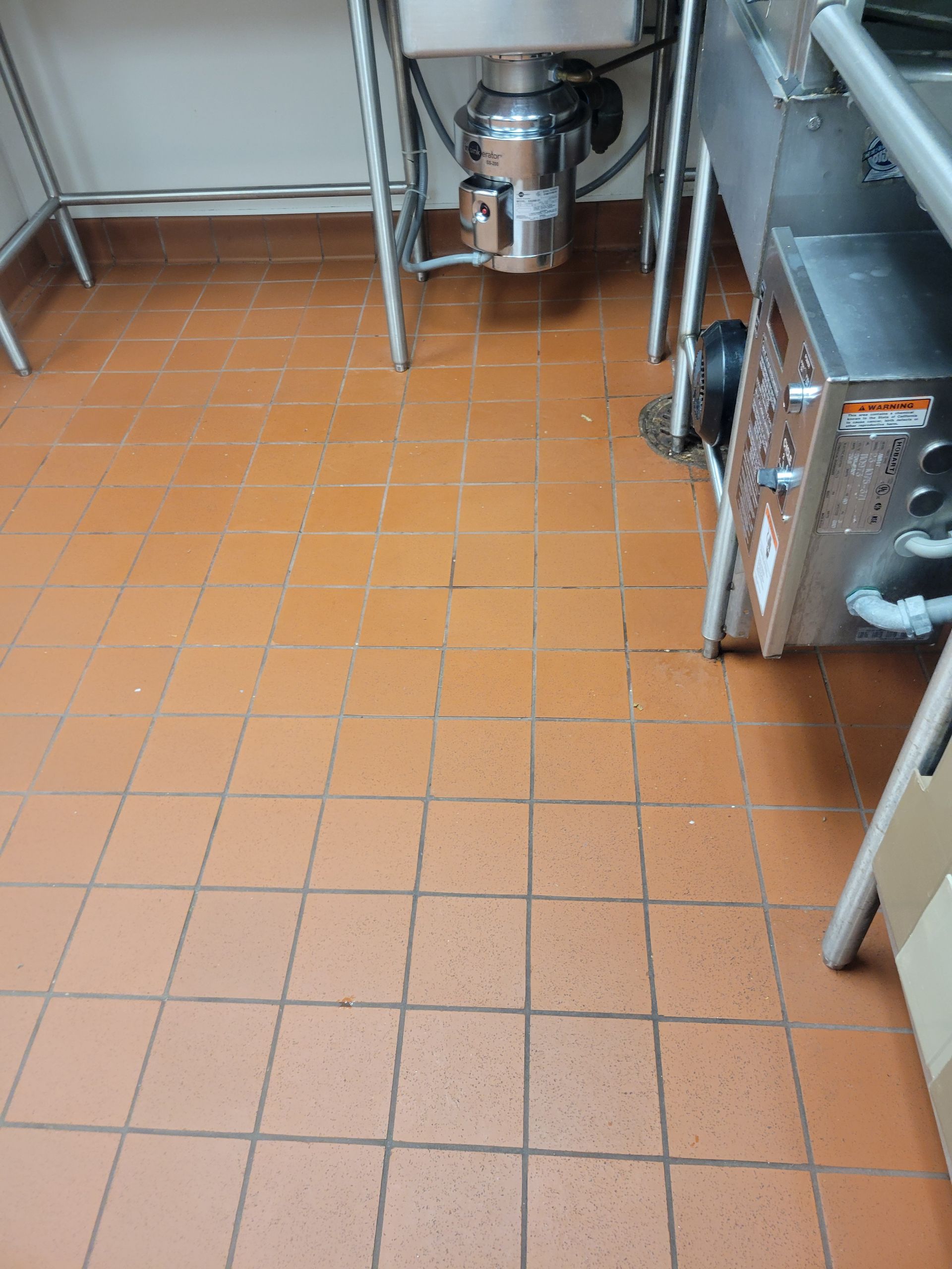 A kitchen with red tile floors and a sink.