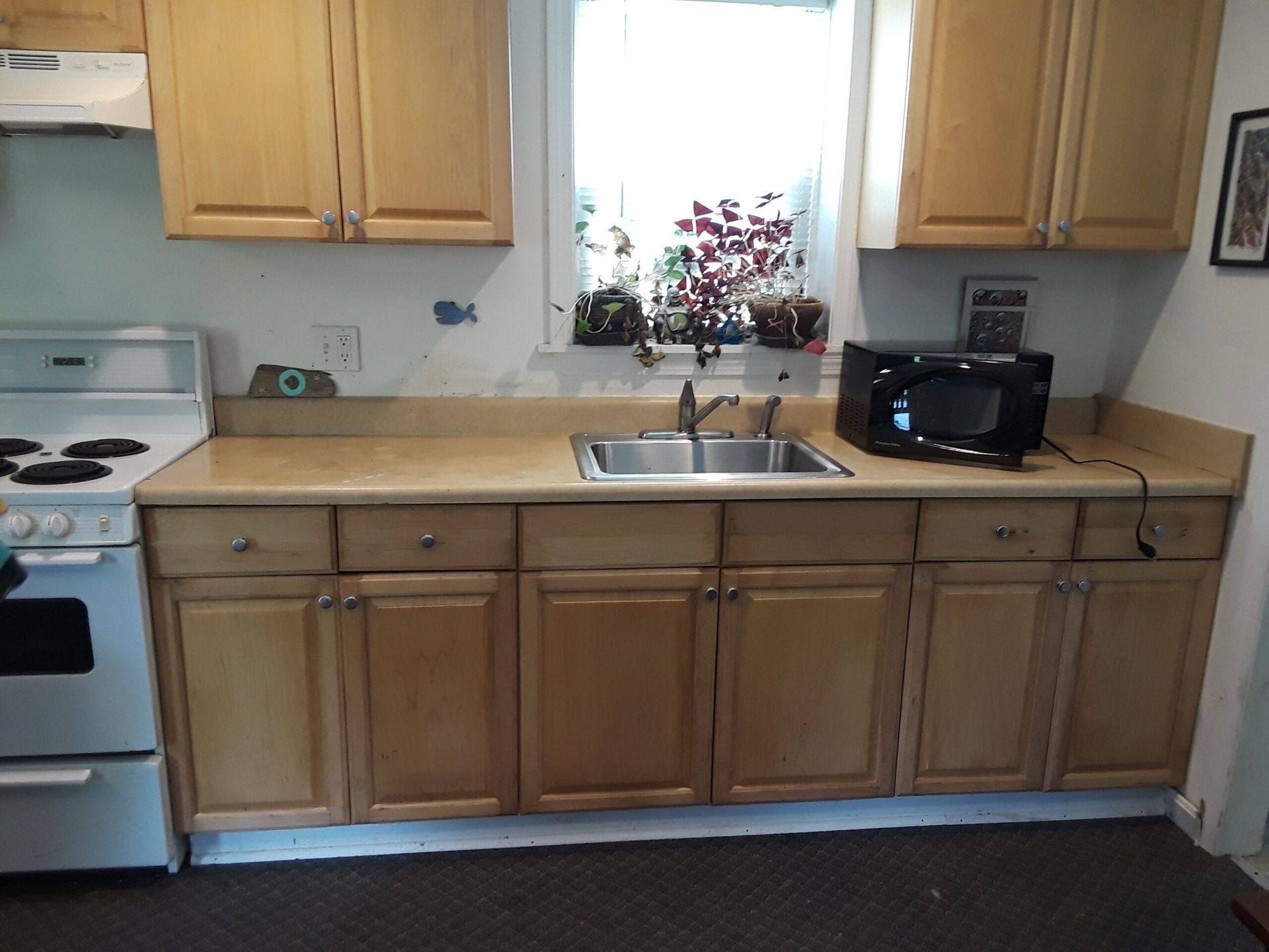A kitchen with a sink stove and microwave