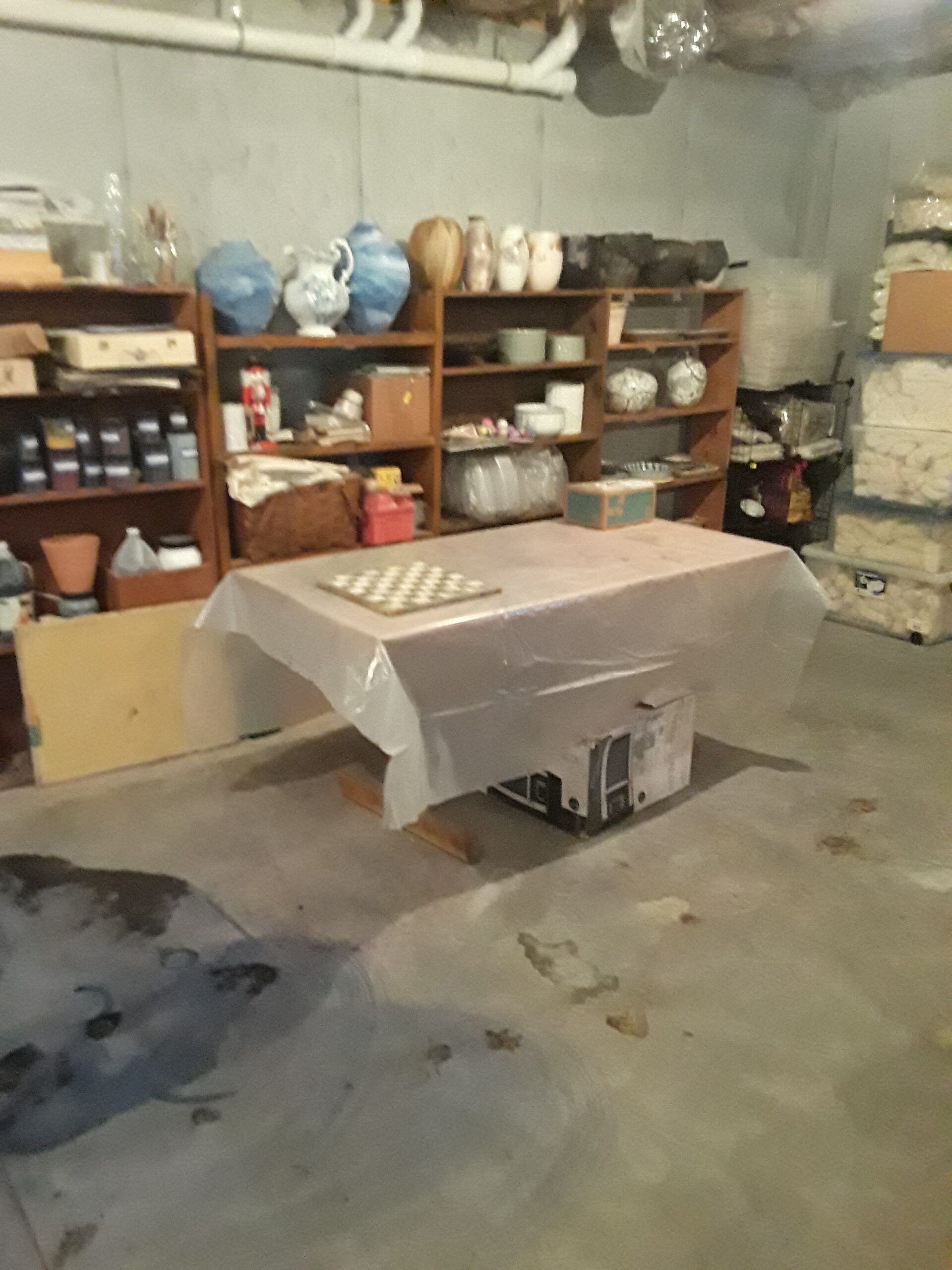 A room with a table and shelves full of vases