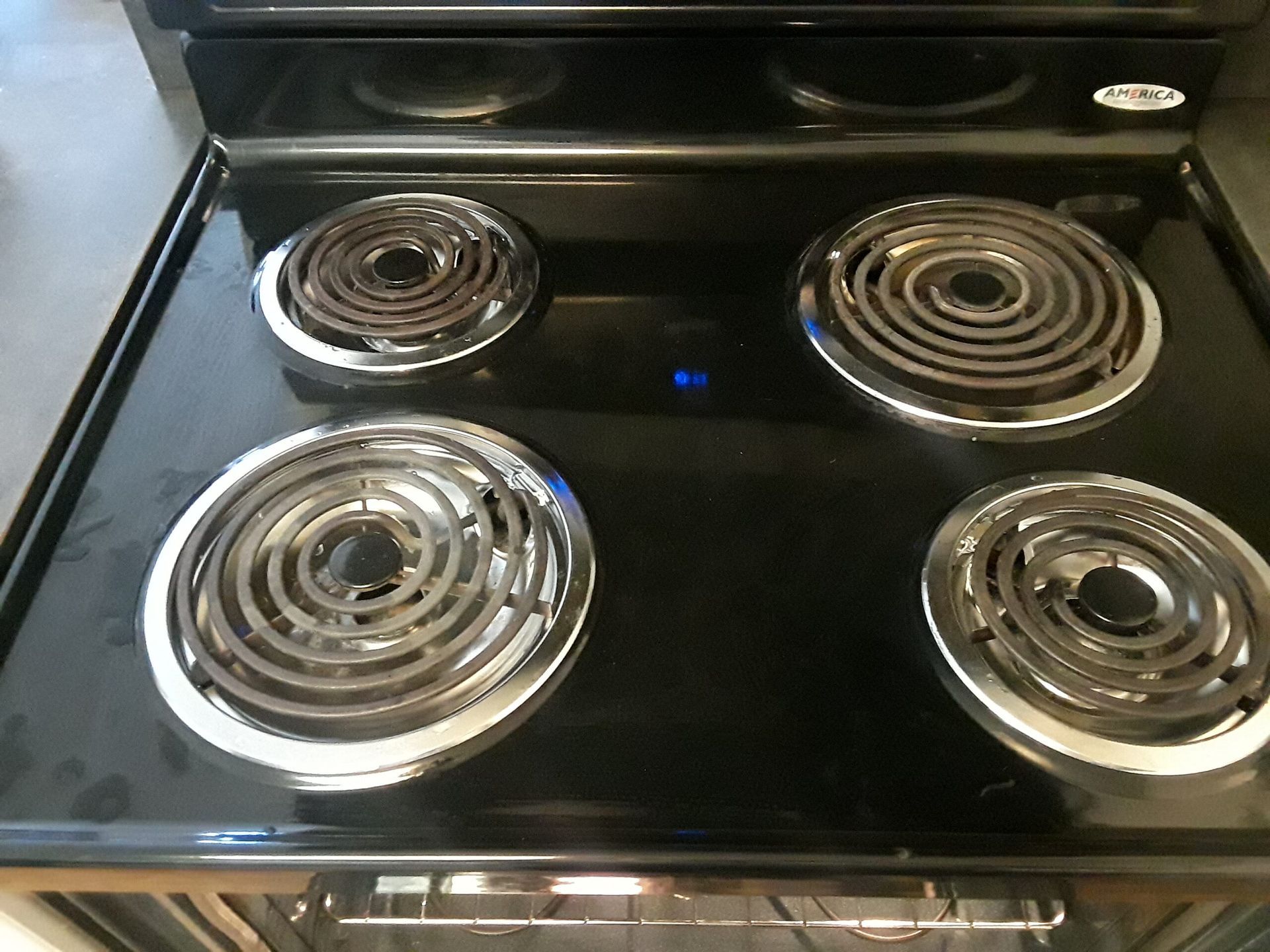 A black electric stove top with four burners