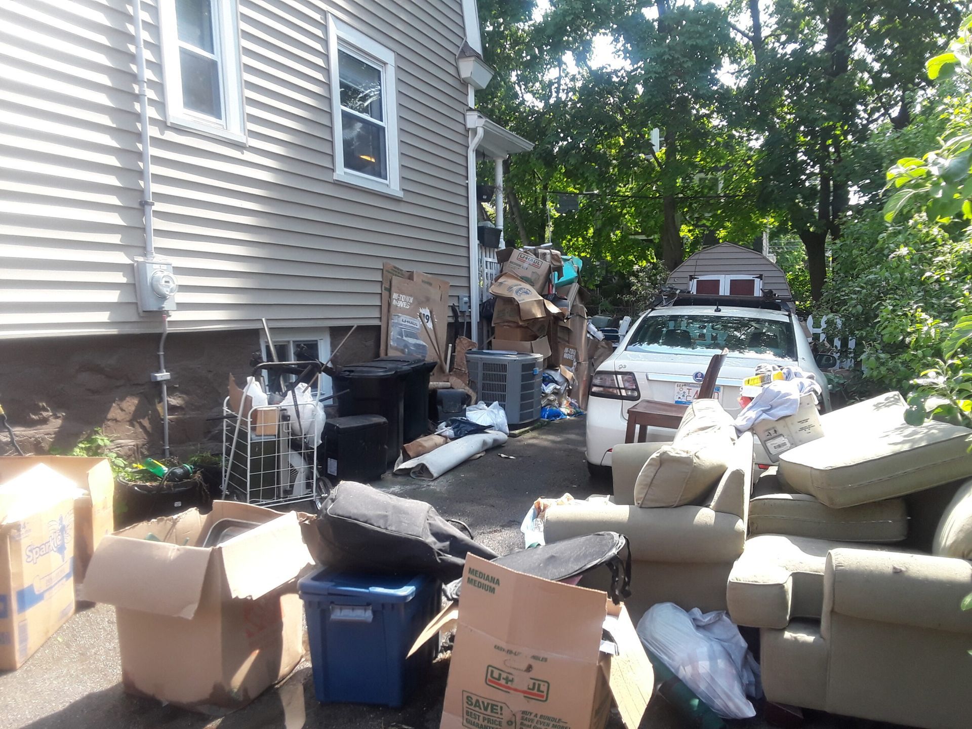A house with a lot of furniture and boxes in front of it