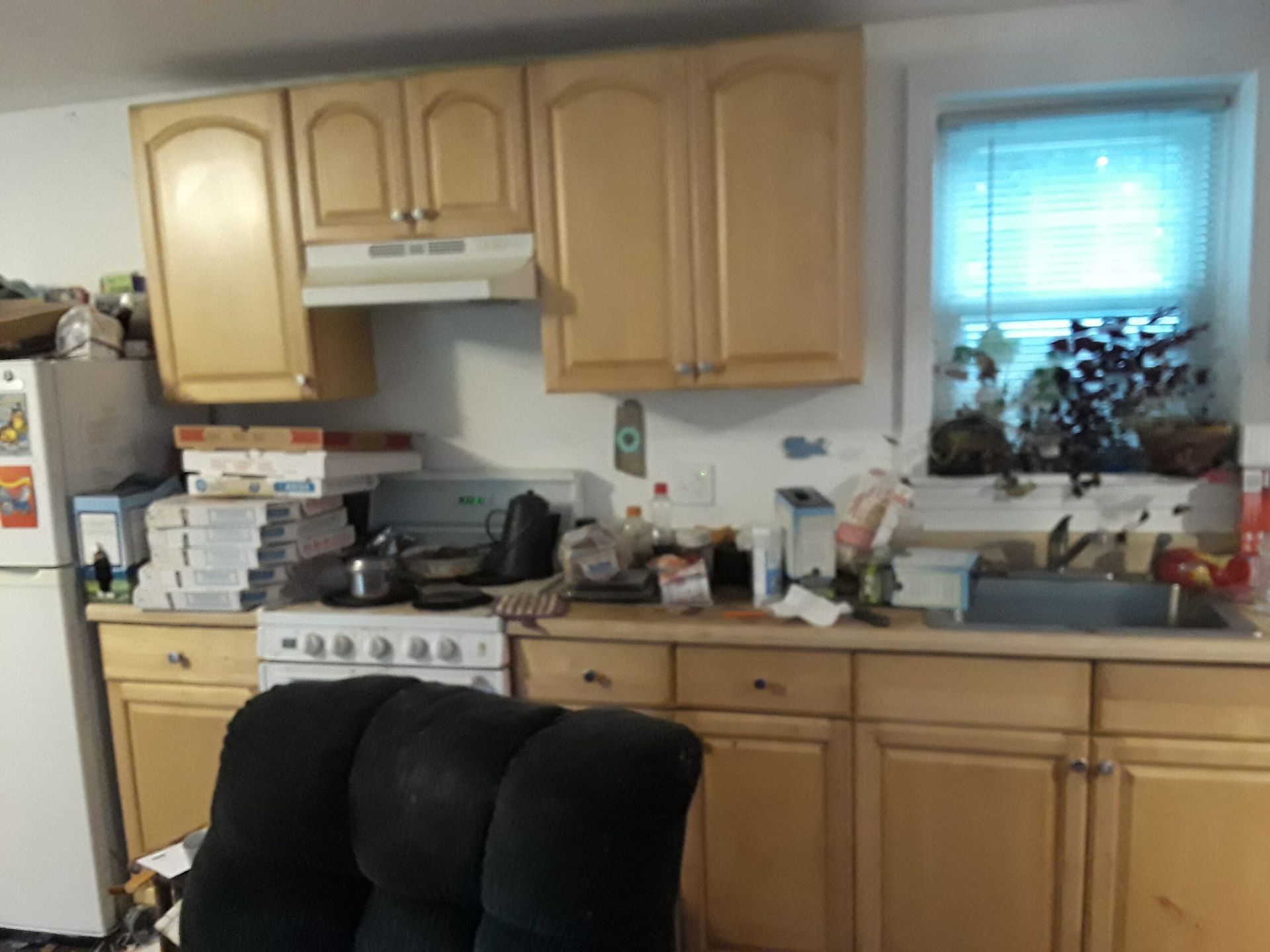 A kitchen with wooden cabinets and a black chair