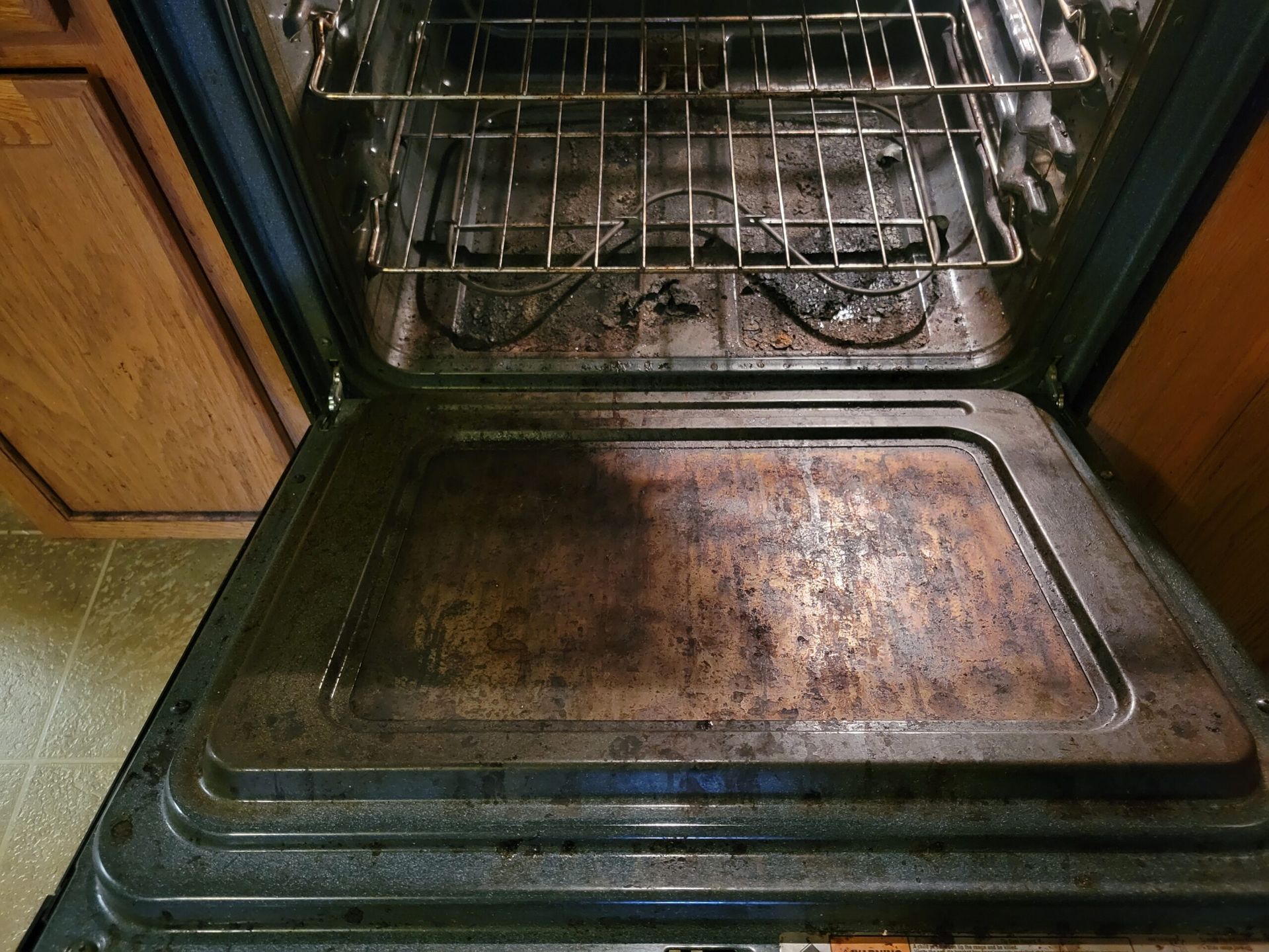 The inside of a dirty oven with the door open.