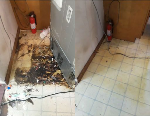 A fire extinguisher is on the floor next to a refrigerator