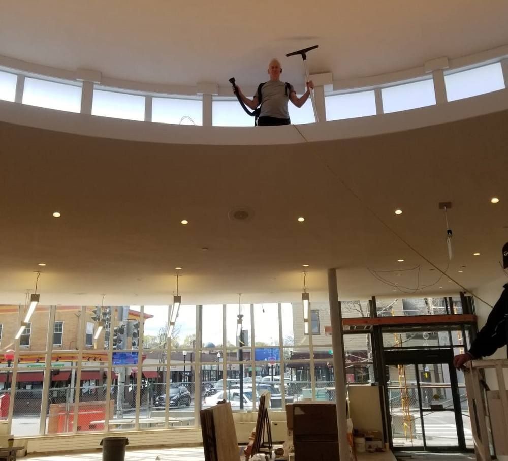 A man is cleaning the ceiling of a building