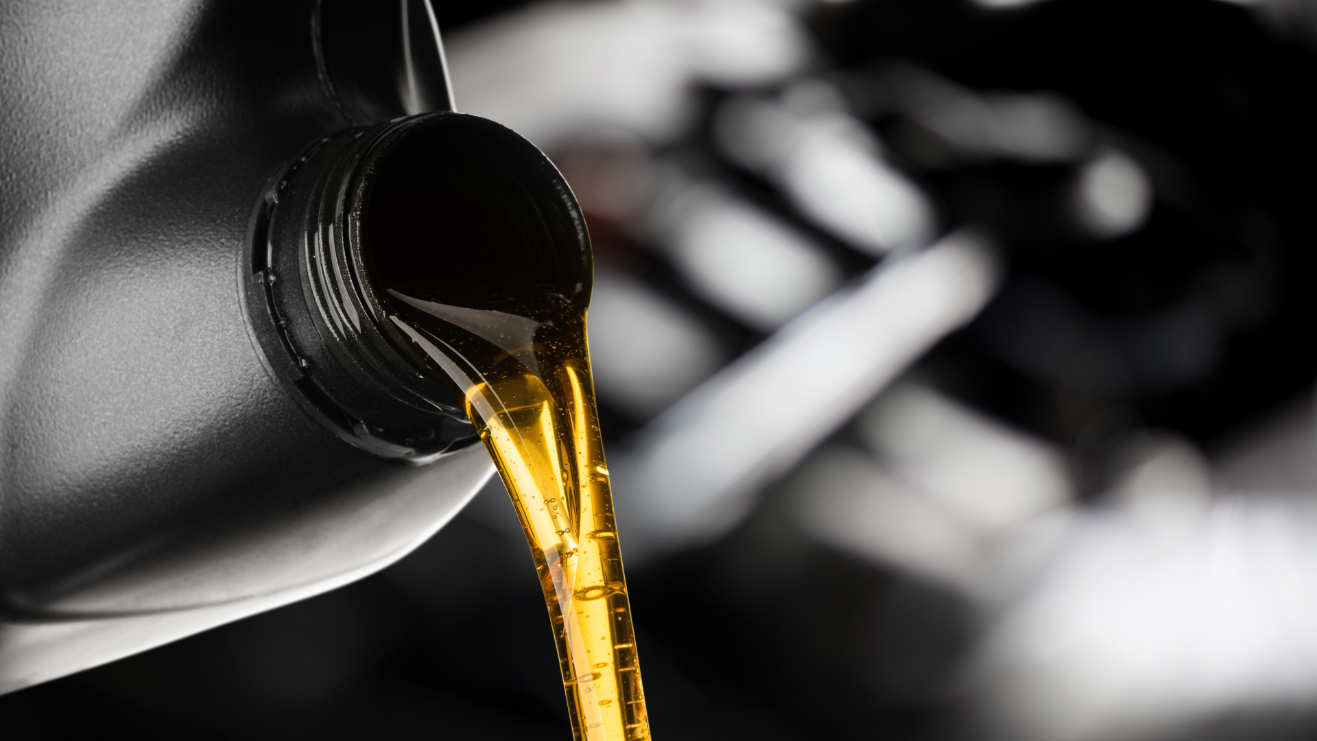 A person is pouring oil into a car engine.