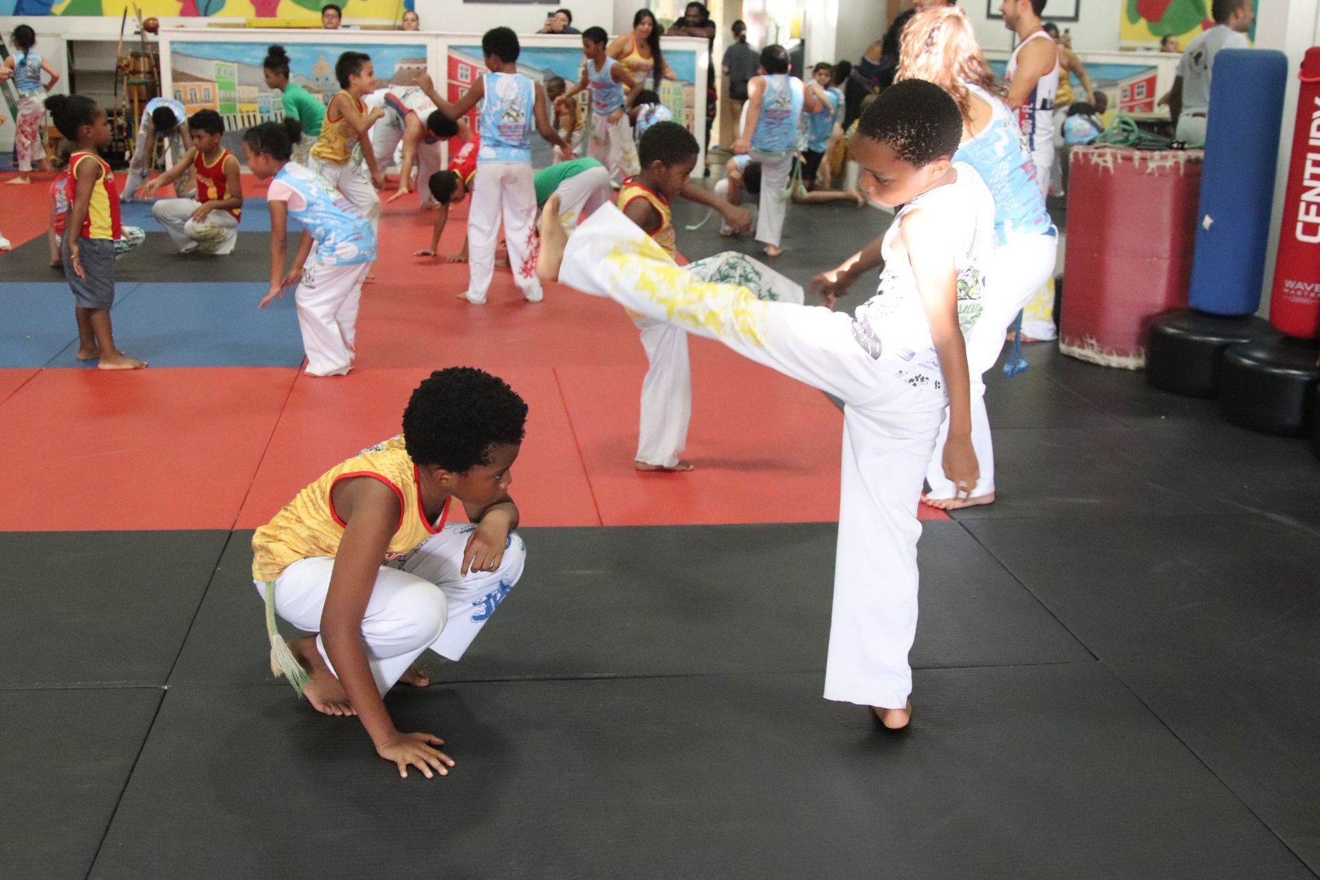 a group of children are practicing martial arts in a gym .