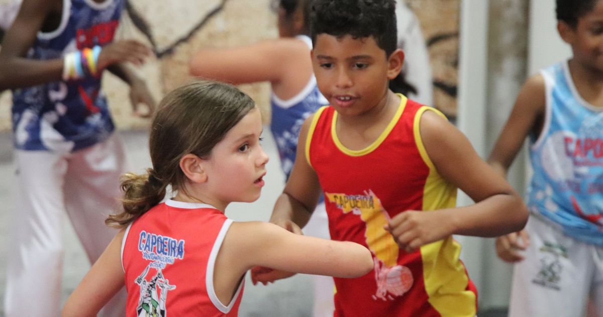 a boy and a girl are dancing together in a gym .