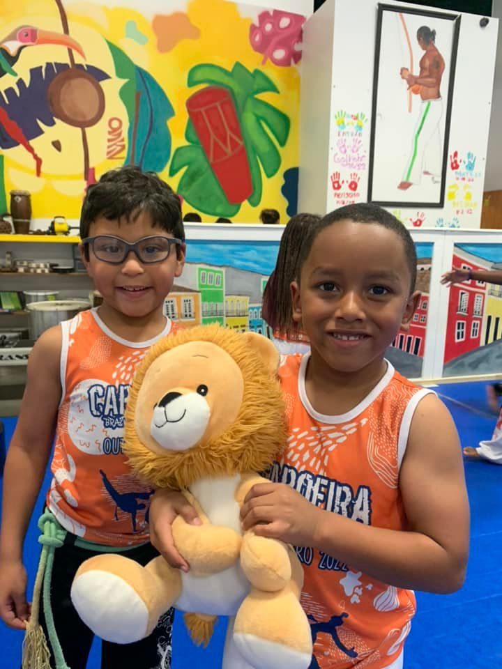 two young boys are holding a stuffed lion in their hands
