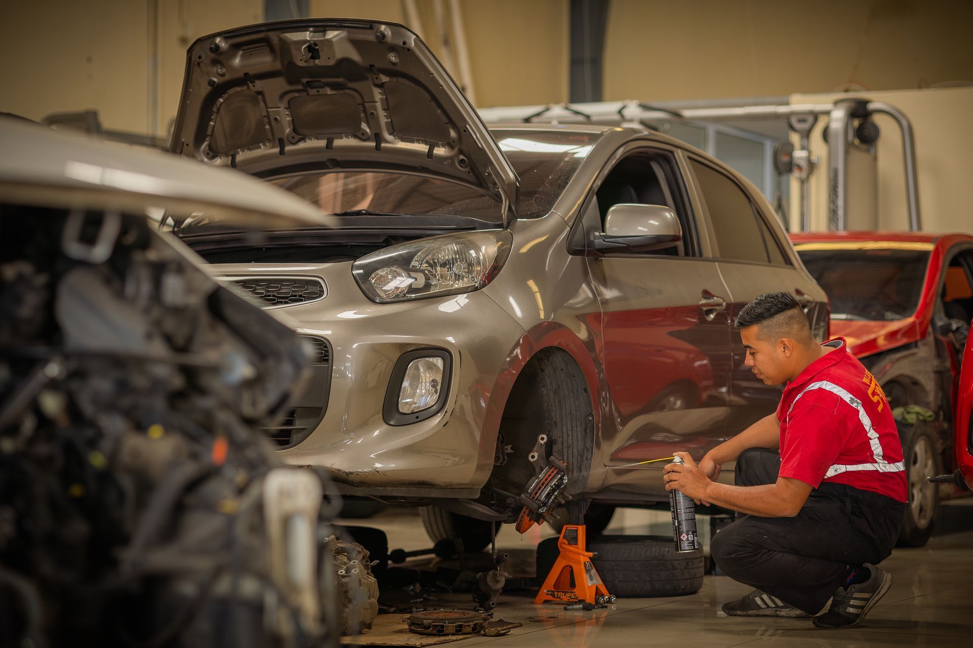 Un hombre está trabajando en un coche en un garaje.