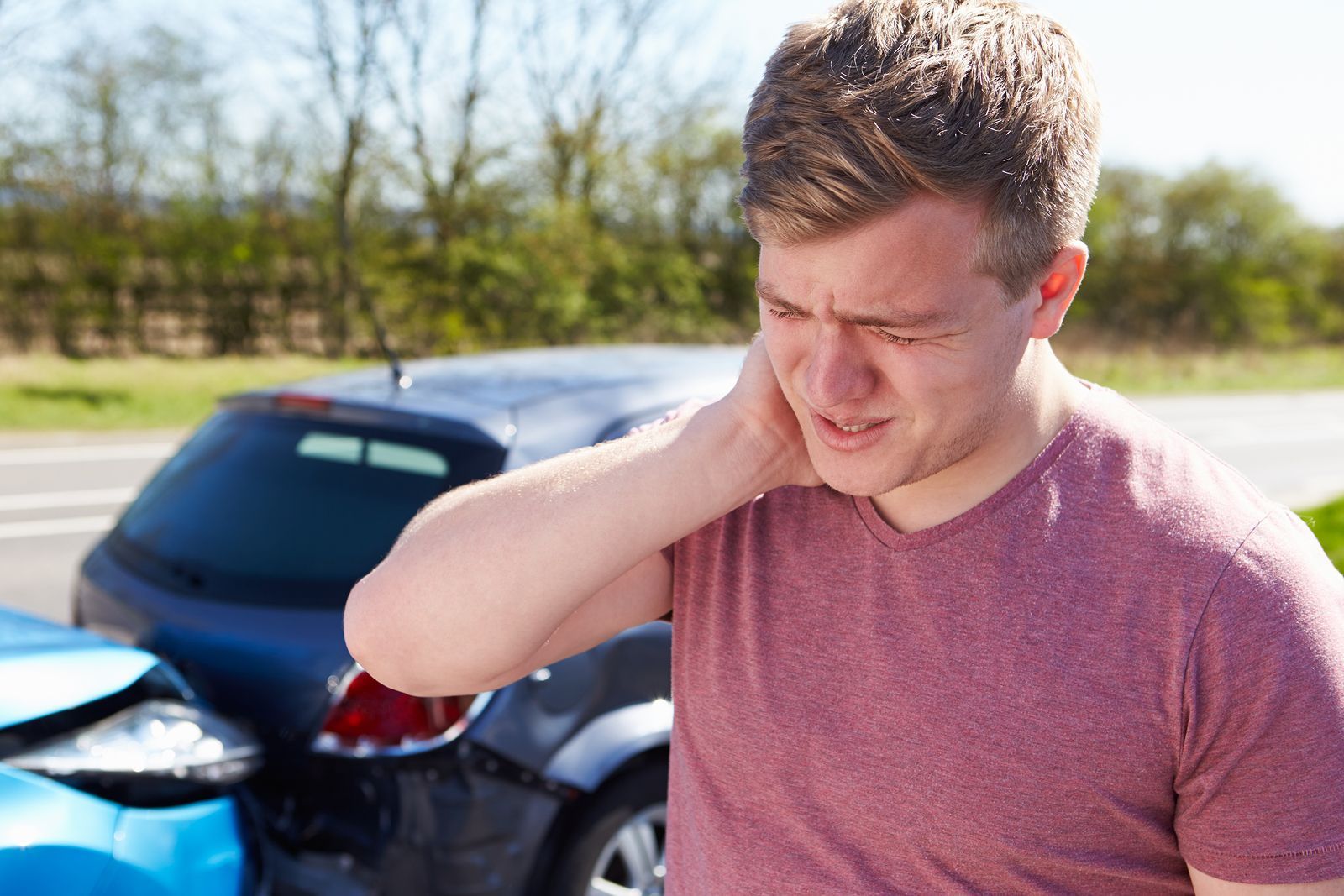 Man feeling whiplash from car accident.