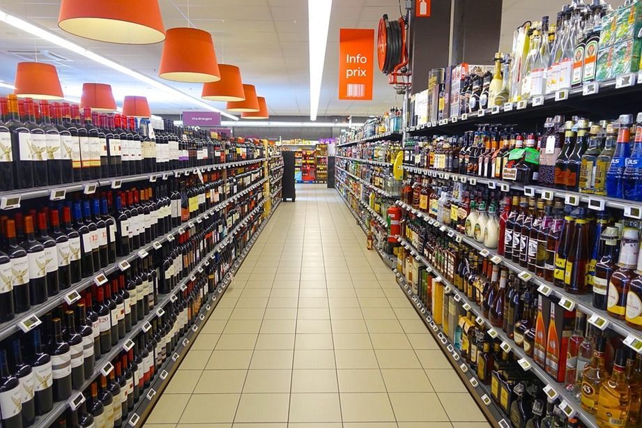 Filas de botellas de licor y vino en el pasillo de un supermercado con tecnología RFID