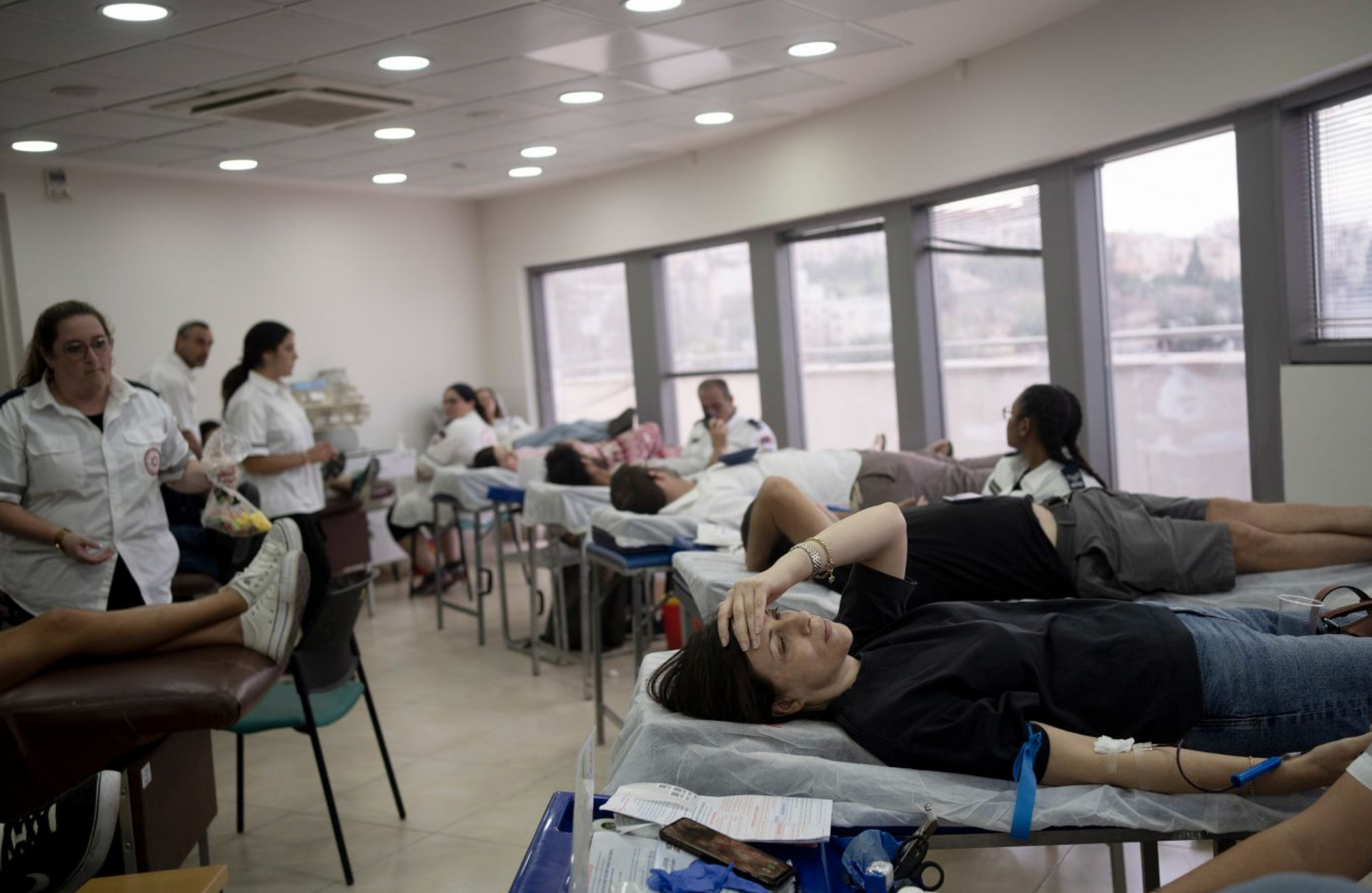 A group of people are laying on beds in a room.