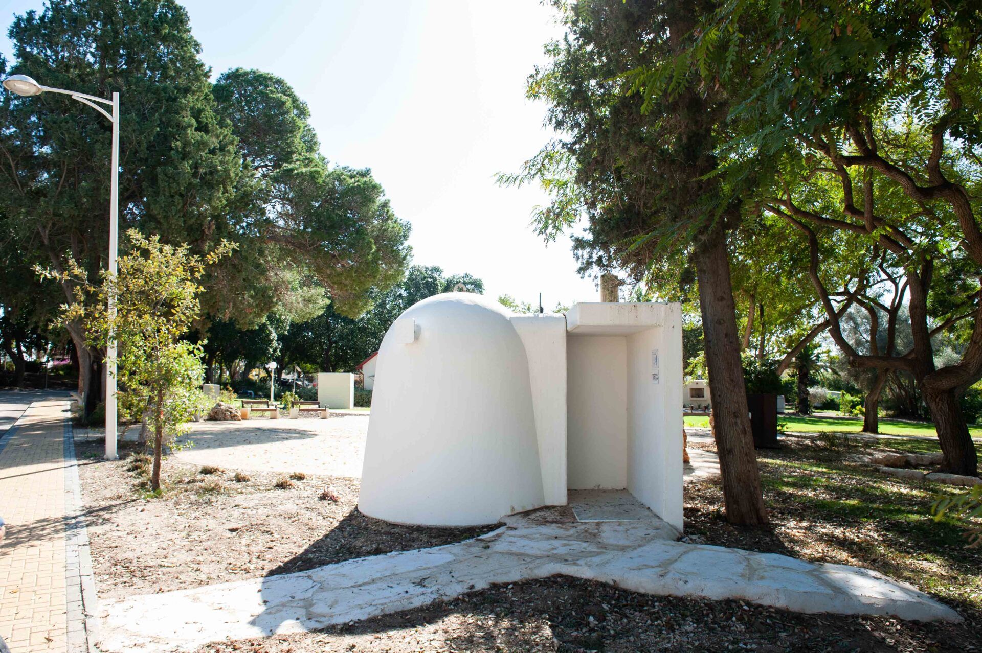 A white dome shaped building in the middle of a park