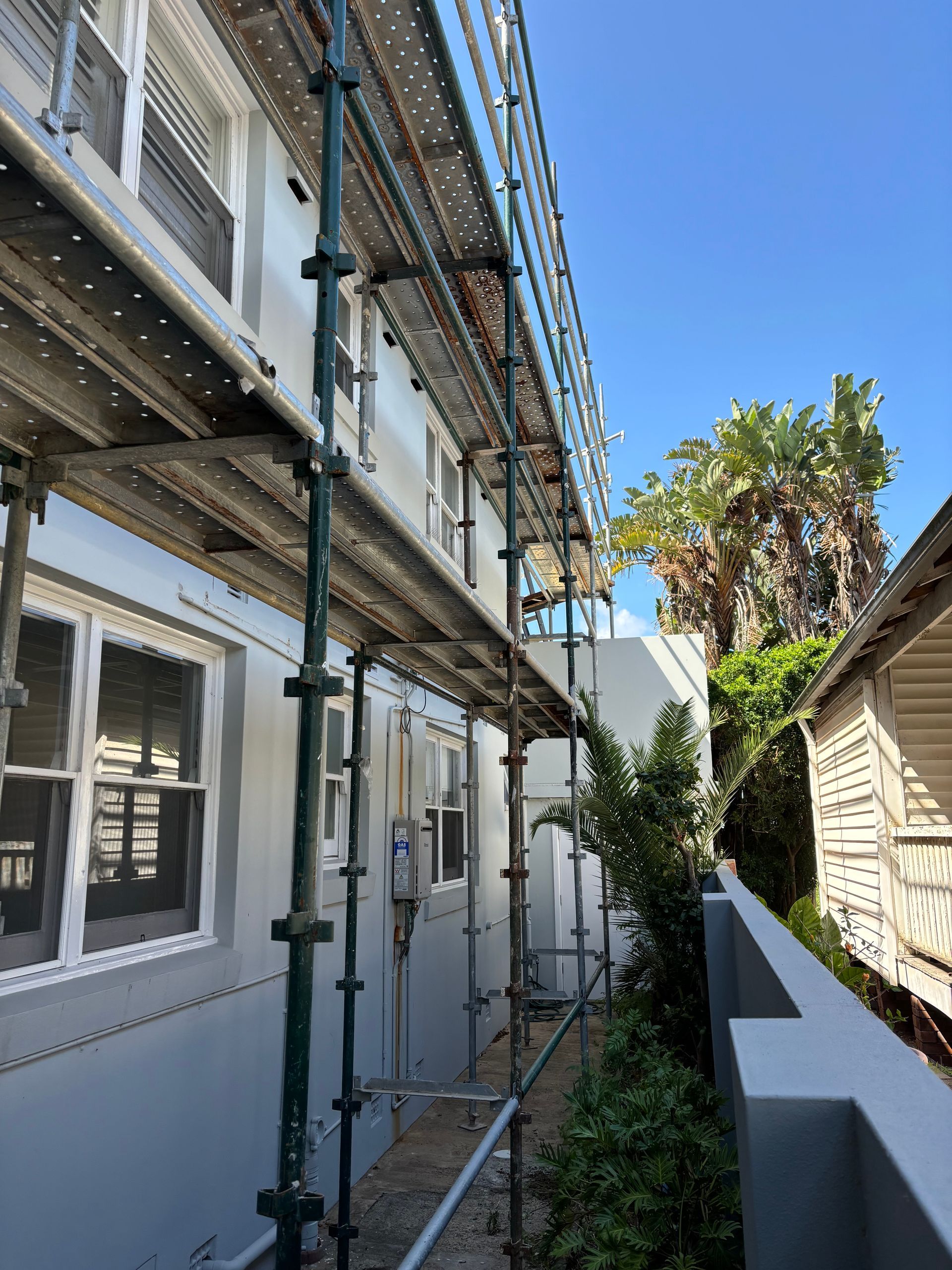 Scaffold installed along residential building for safe window and wall access.