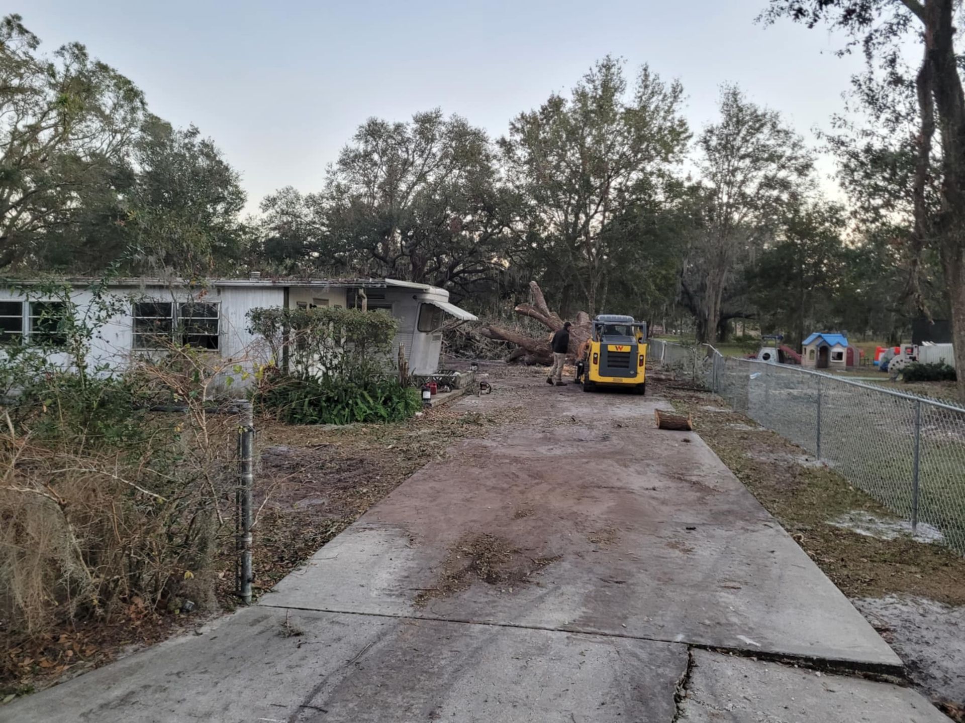 A house is being demolished with a bulldozer in the background