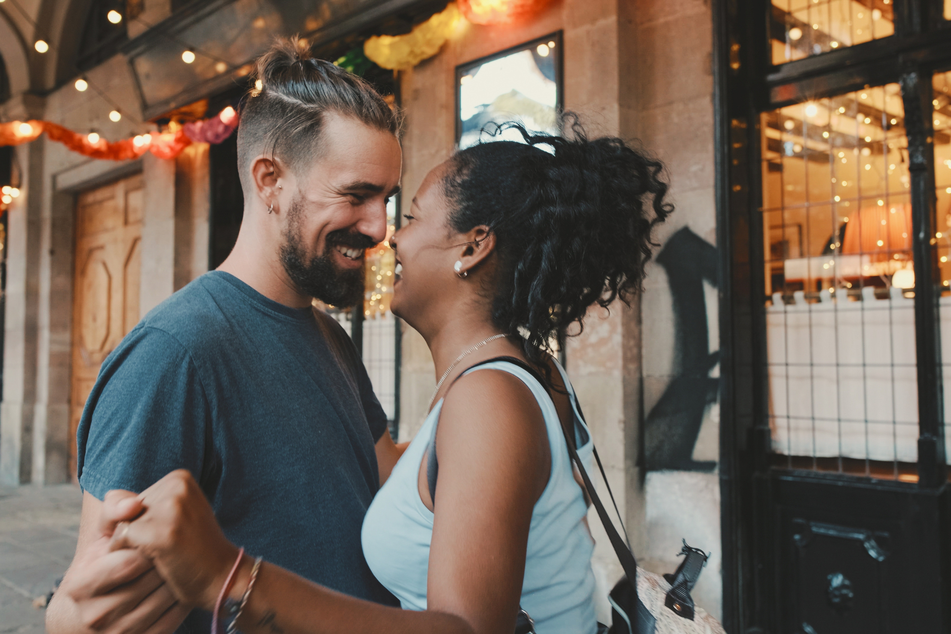 A man and a woman are dancing in front of a building.