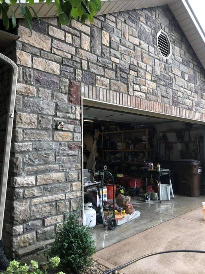 A garage with a brick wall and a sliding garage door.