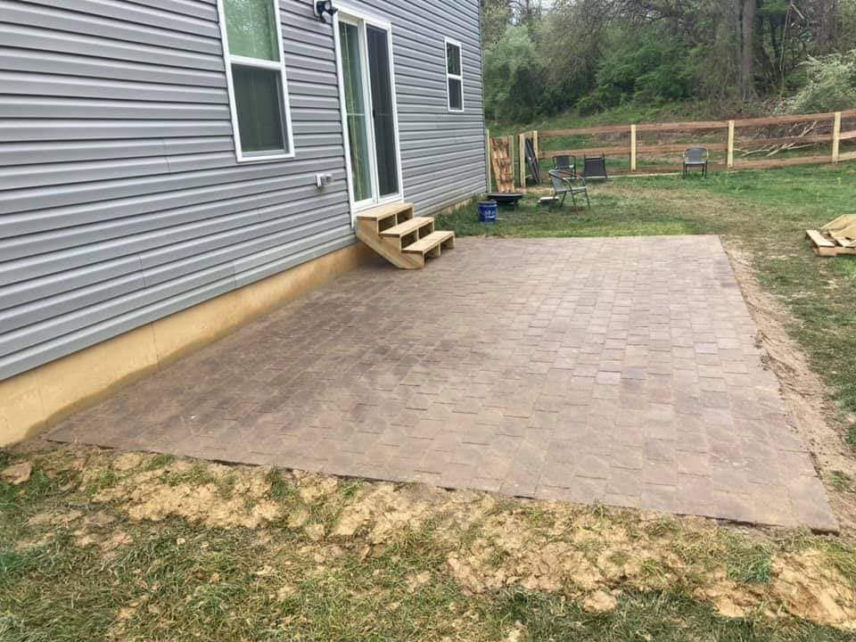 A backyard with a patio and stairs in front of a house.