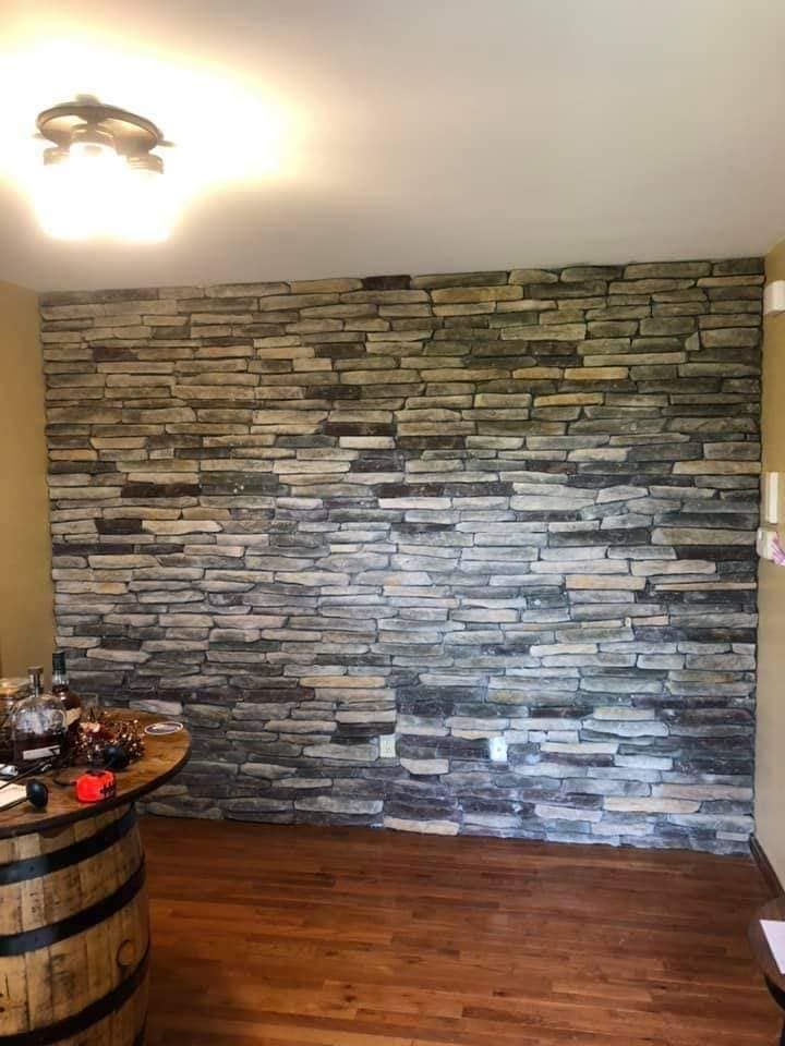 A room with a stone wall and a wooden floor.