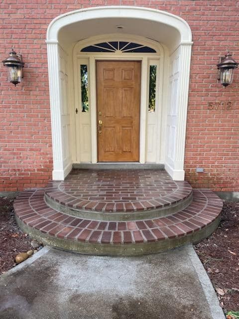 A brick house with a wooden door and a brick porch.