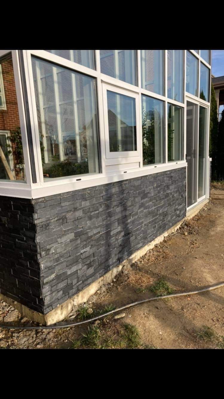 A house with a lot of windows and a brick wall.
