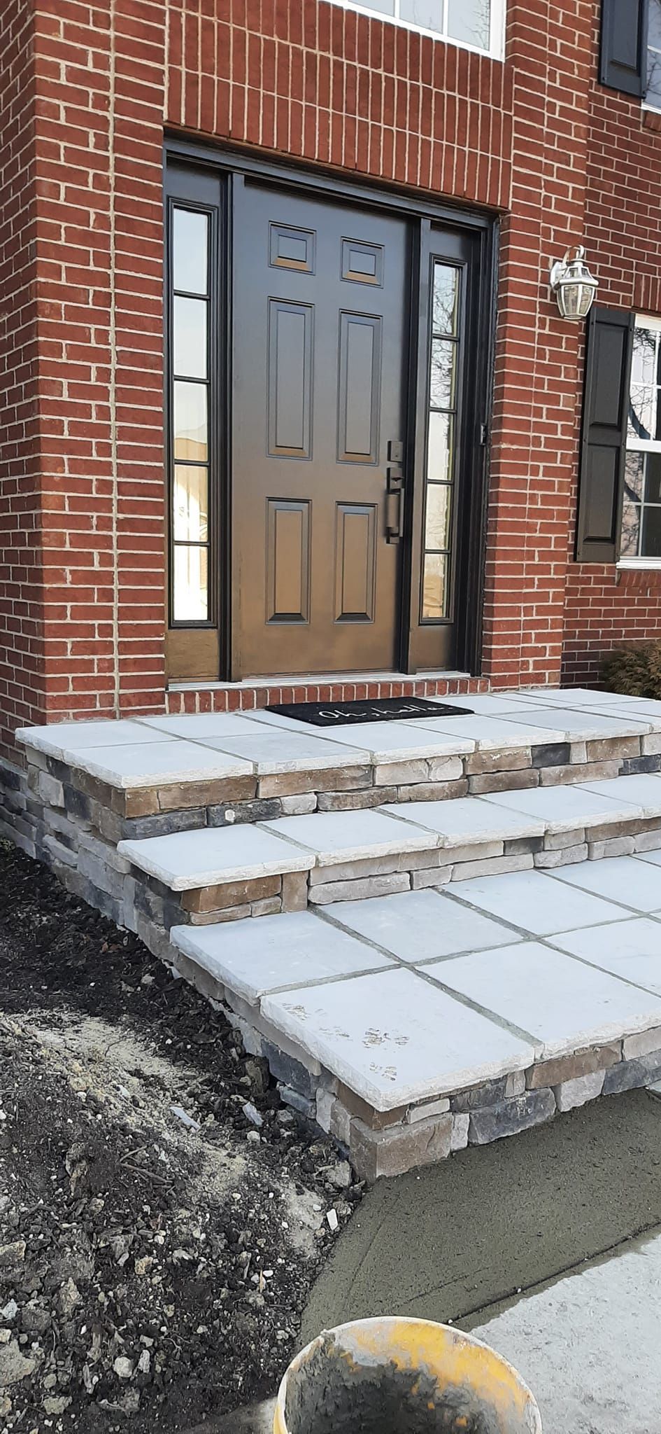 A brick house with stairs leading up to the front door.