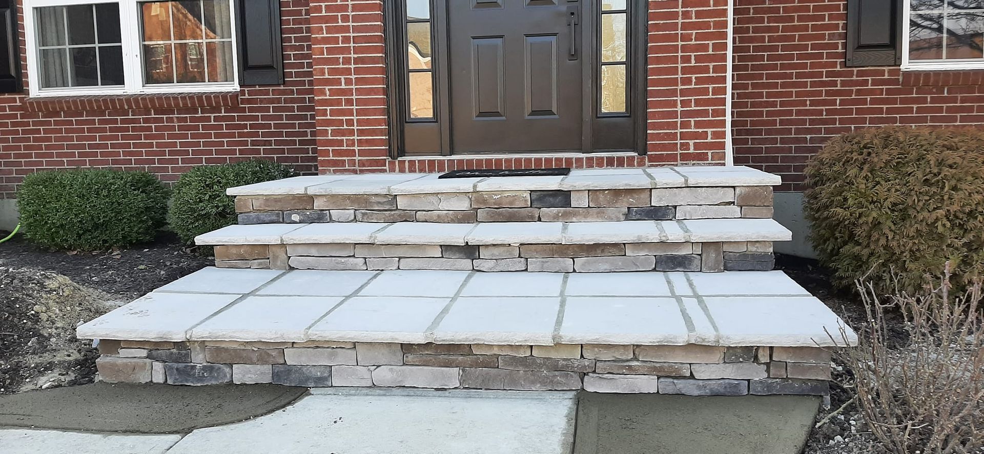 A brick house with stone steps leading up to the front door