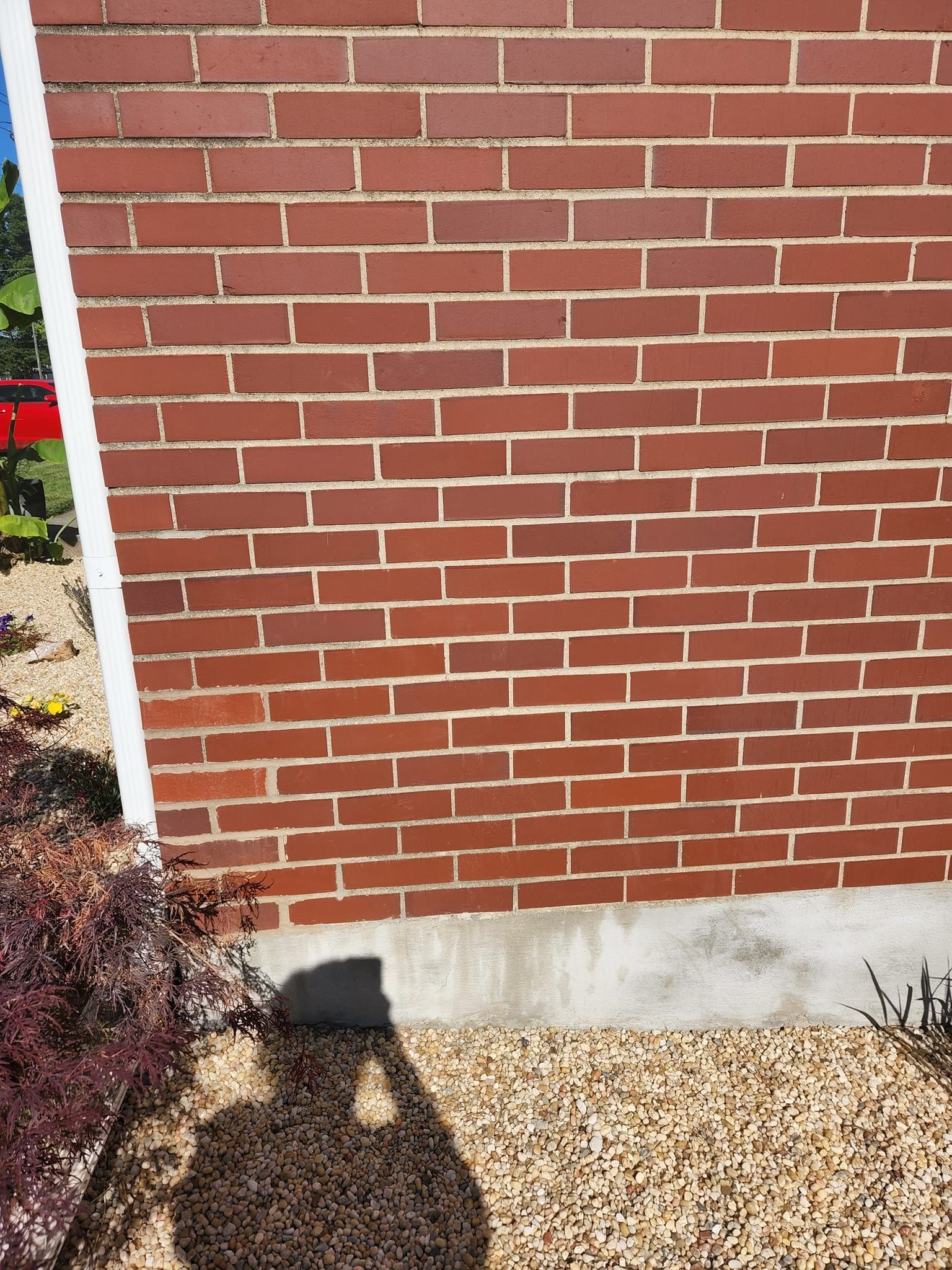 A brick wall with a shadow of a person on it.