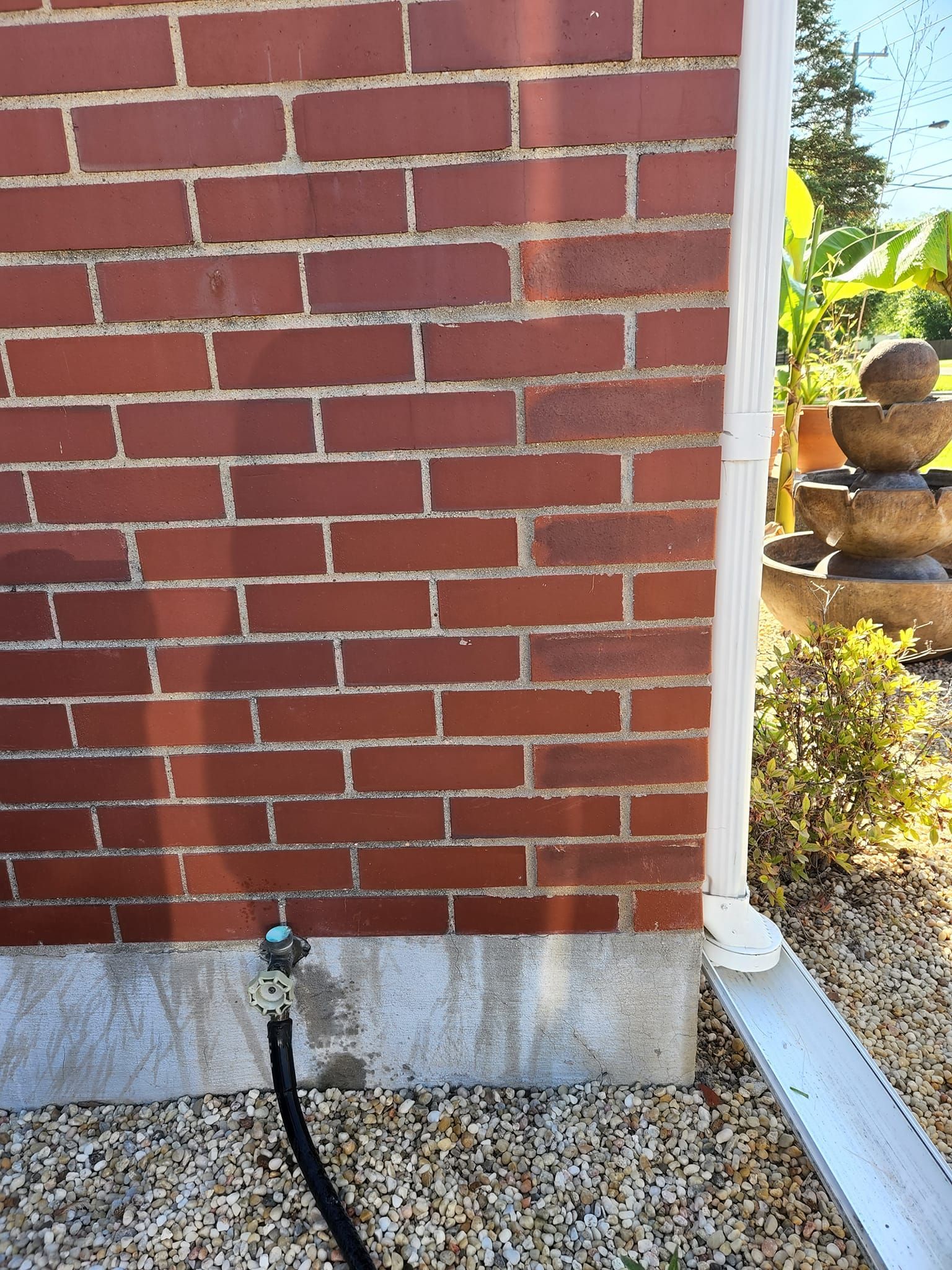 A brick wall with a hose attached to it