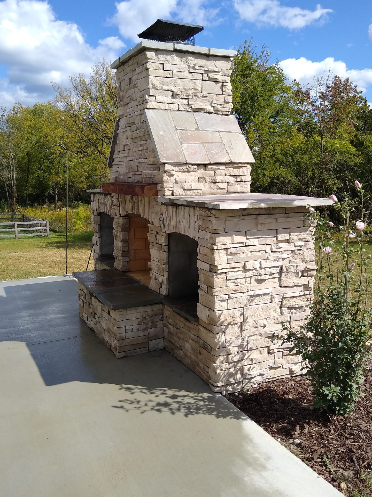 A stone fireplace with a bird on top of it