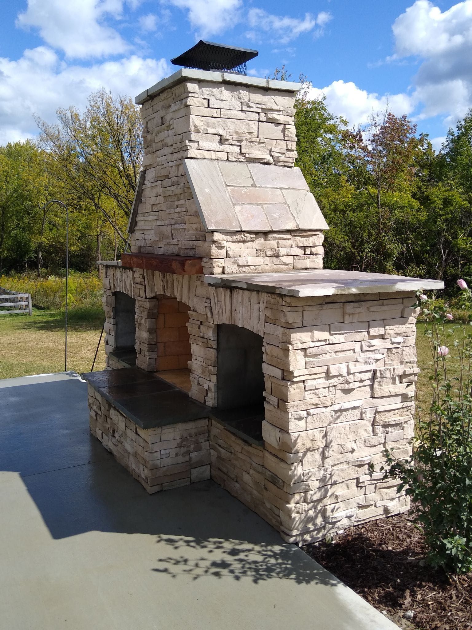 A stone fireplace with a chimney on top of it