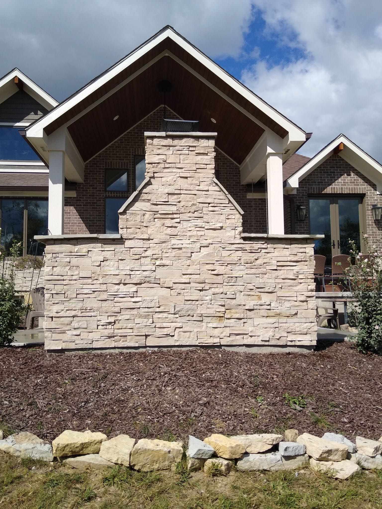 A brick house with a stone fireplace in front of it