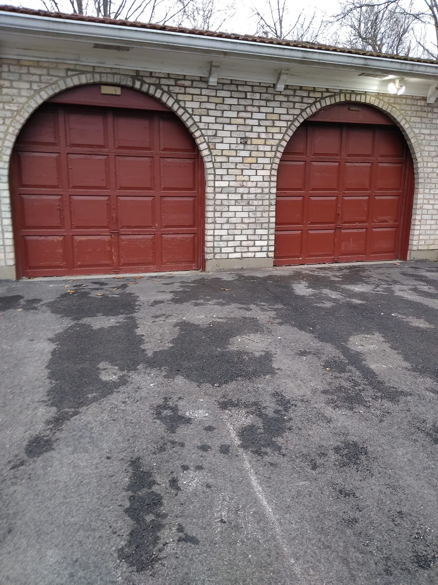 A couple of red garage doors on a brick building.