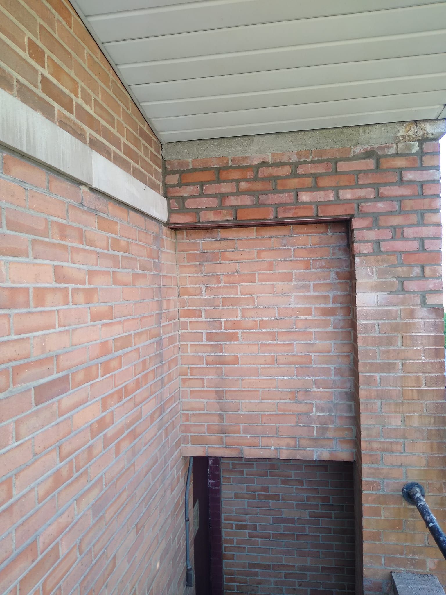 A brick wall with a hole in the middle of it